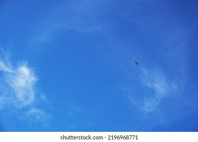 Clear Blue Sky With Cirrus Clouds, An Airplane Flies In The Sky. Selective Focus.