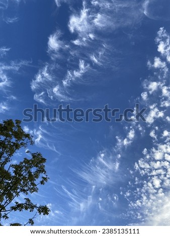A clear blue sky with fleecy clouds