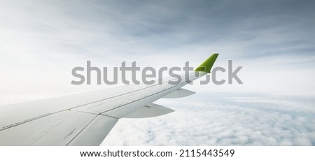 Clear blue sky with fluffy ornamental cumulus clouds, panoramic view from an airplane, wing close-up. Dreamlike cloudscape. Travel, tourism, vacations, weekend, freedom, peace, hope, heaven concepts