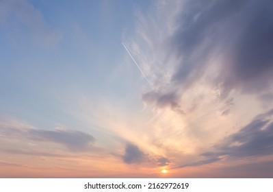Clear blue sky. glowing pink and golden cirrus and cumulus clouds after storm, soft sunlight. Dramatic sunset cloudscape. Meteorology, heaven, peace, graphic resources, picturesque panoramic scenery