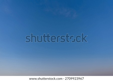 Clear blue sky with light clouds and gradient horizon