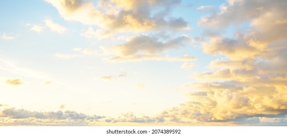 Clear blue sky, pink and golden cirrus and cumulus clouds after storm at sunset. Dramatic cloudscape. Concept art, meteorology, heaven, hope, peace, graphic resources, picturesque panoramic scenery