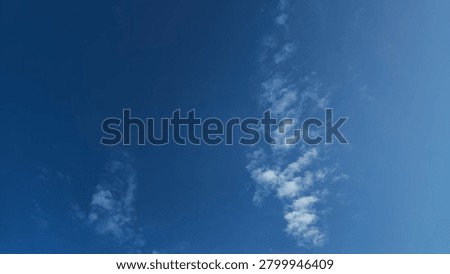 Clear blue sky texture backdrop with light scattered cirrus clouds. Natural gradient blue sky background