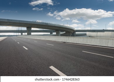 Clear blue sky and white clouds in the background, highway overpass curved approach bridge 