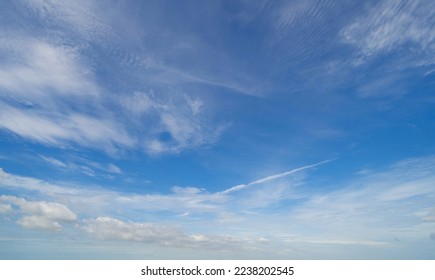 Clear blue sky with white fluffy clouds at noon. Day time. Abstract nature landscape background.