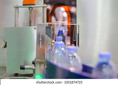 Clear Bottles transfer on Conveyor Belt System. Clear bottle moving on labelling machine in a factory.