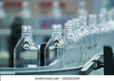 Clear Bottles transfer on Conveyor Belt System. Clear bottle moving on labelling machine in a factory.