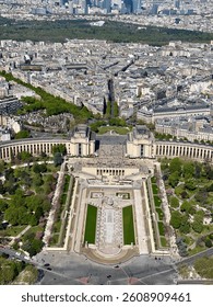 A clear daytime view of the Eiffel Tower in Paris, France, with a blue sky and surrounding greenery. A famous Parisian landmark and popular travel destination.