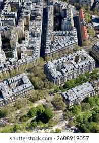 A clear daytime view of the Eiffel Tower in Paris, France, with a blue sky and surrounding greenery. A famous Parisian landmark and popular travel destination.