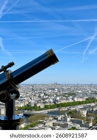 A clear daytime view of the Eiffel Tower in Paris, France, with a blue sky and surrounding greenery. A famous Parisian landmark and popular travel destination.