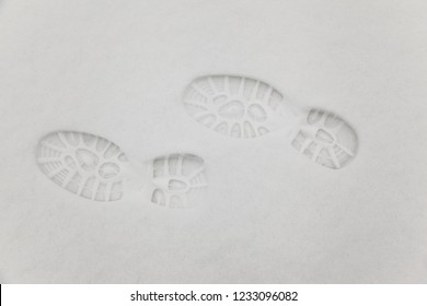 Clear Deep Footprints On White Winter Snow Of A Pair Of Boots,track In Snow, Overhead View. Texture Of Snow Surface