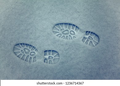 Clear Deep Footprints On White Winter Snow Of A Pair Of Boots,track In Snow, Overhead View. Texture Of Snow Surface