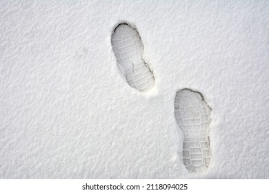 Clear deep footprints on white winter snow of a pair of boots. Track in snow. Overhead view. Texture of snow surface.foot prints in fresh snow - Powered by Shutterstock