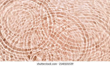 A lot of clear drops fall down creating rings on water surface on beige background | Beauty product background shot for its commercial