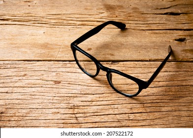 Clear Eyeglasses Glasses With Black Frame Fashion Vintage Style On Wood Desk Background, Rustic Still Life Style.