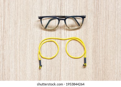 Clear Eyeglasses, Glasses Transparent Dark Blue Frame With Yellow Eyeglasses Strap On A Wooden Background