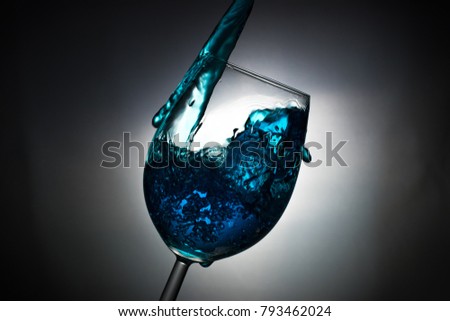 
?rystal clear glass with blue liquid in action. 