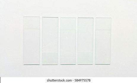 Clear Glass Microscope Slides, Ground Edges On White Background.