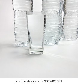 Clear Glasses Drinking Water Bottles Lined Up On White Background 