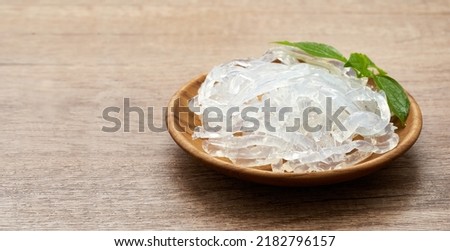 clear kelp or seaweed noodles in a wooden plate on wooden background. glass noodle                                  