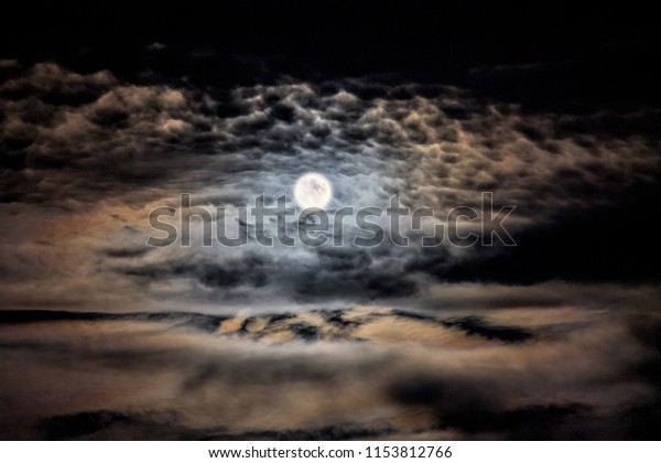 Clear\
moonlit night. Moon and clouds in the night\
sky