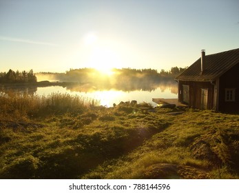 A clear morning view of a house over a lake in the sunrise