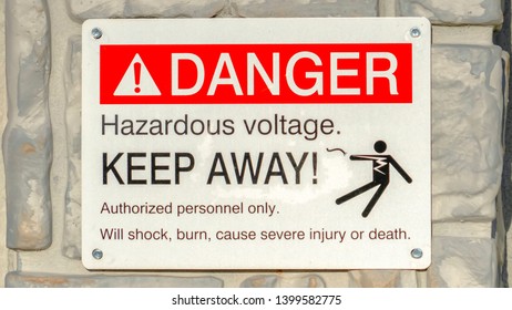 Clear Panorama Close Up Of Danger Hazardous Voltage Keep Away Sign Posted On A Gray Surface