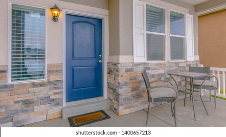 Clear Panorama Exterior Of A Home With Blue Wooden Front Door And Reflective Glass Windows