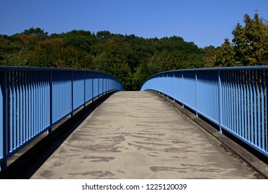 A Clear Path Ahead - Symmetrical View Of A Pedestrian Bridge Into A Forest