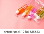 Clear Plastic Bag Containing Travel-Sized Toiletries on Pink Background