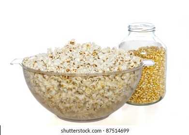 Clear Plastic Bowl Of Popcorn And Glass Jar Of Unpopped Seeds