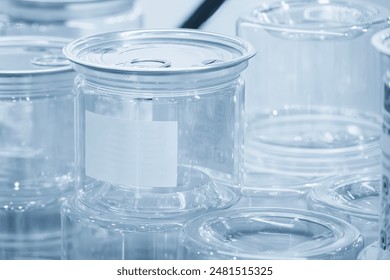 The clear plastic container with aluminum lid in the light blue scene. The plastic container manufacturing process.
