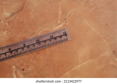 Clear Plastic Ruler On A Marble Ceramic Background