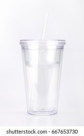 Clear Plastic Tumbler Glass With Lid And Straw On A White Surface. Travel Cup Isolated On White Background.