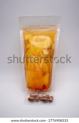 A clear pouch is filled with an inviting assortment of citrus fruits and refreshing beverages, accompanied by a delectable snack