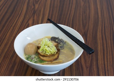 Clear Ramen Or Yellow Noodle Soup With Roasted Marinated Pork And Whole Egg.  Cooked With Slices Of Bamboo Shoot And Chinese Black Fungus.  Garnished With Spring Onion And Fresh Shredded Vegetable.