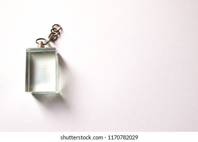 A Clear Rectangle Shape Glass Key Chain On The White Background.