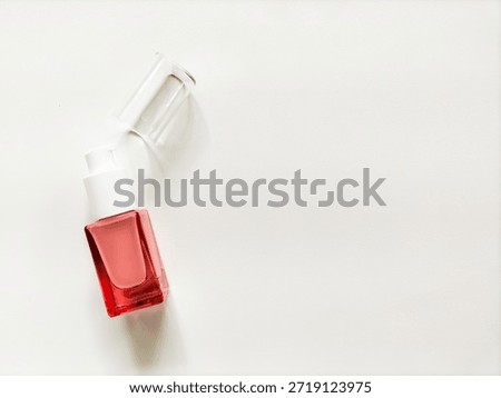 A clear rectangular skincare bottle with a white pump dispenser sits on a whitebackground.