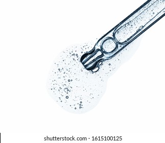 Clear serum in pipette isolated on white background. Cosmetic liquid dropper with bubbles top view.