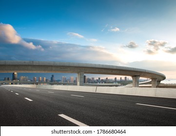 The clear sky in the evening, the curved approach bridge of the highway overpass leading to the city