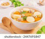 Clear soup with tofu and minced pork in white bowl on white table background. Asian Food