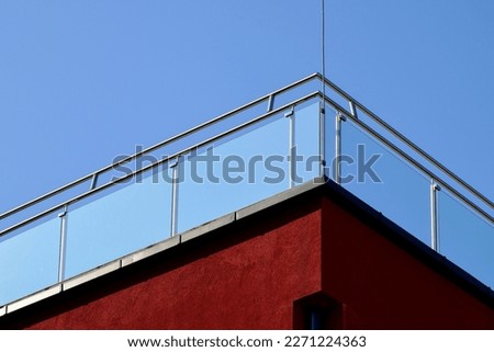 Clear tempered glass balcony balustrade. stainless steel pipe guard rail. building corner. exterior detail. stucco facade. modern architecture. low angle view. bright summer lights. clear blue sky Foto stock © 