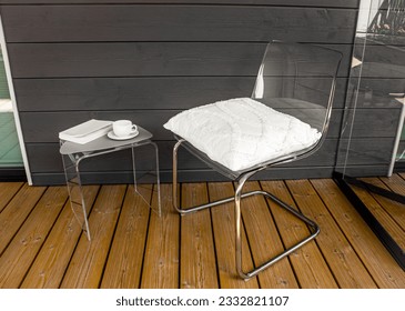 Clear transparent modern acrylic furniture in home. Chair with pillow, side table with tea cup and book. Alternative furniture material concept. - Shutterstock ID 2332821107