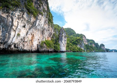Clear Turquoise water with limestone cliffs in Monkey Bay on Phi Phi Island, Krabi, Thailand.