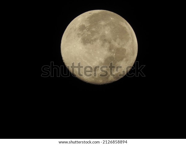 Clear view\
of full moon on dark black sky\
background