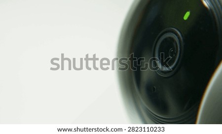 Clear view of a security camera lens featuring an indicator light showing operational status. Focus on design elements suited for home and business surveillance systems.