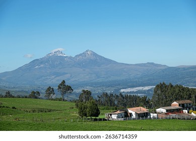 A clear view of the twin Iliniza volcanoes—snow-capped Iliniza Sur and rocky Iliniza Norte—rising above the Andean highlands of Ecuador. 
