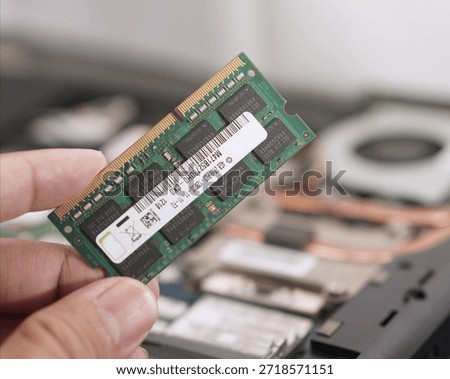 A clear view of a user holding a computer memory component. Perfect for tutorials on how to upgrade laptop RAM, identify hardware parts, or check compatibility.