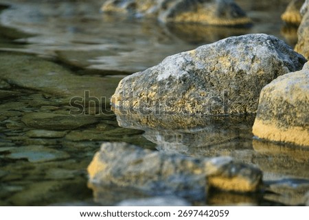 A clear water with the reflection of the rocks