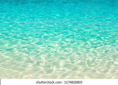 Clear water reflections on shallow sandy beach bottom, Thailand in a summer day